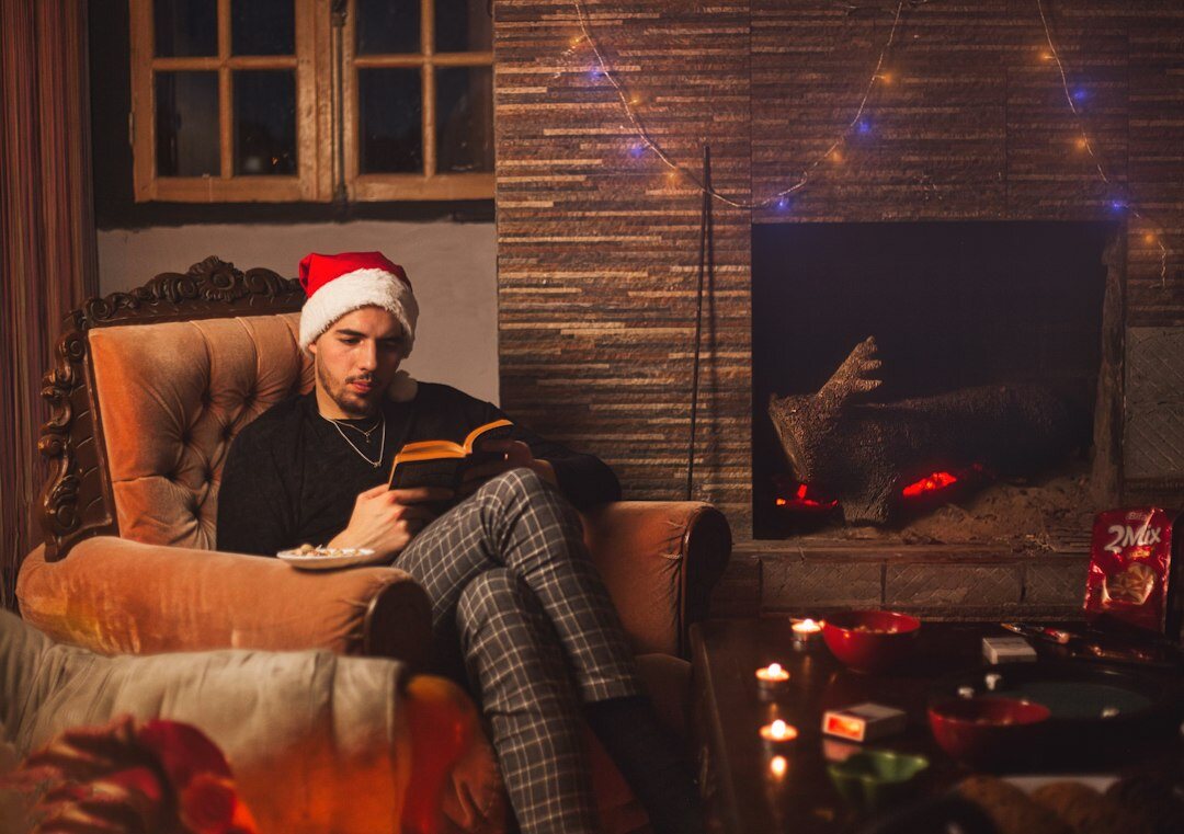 person reading book by fireplace